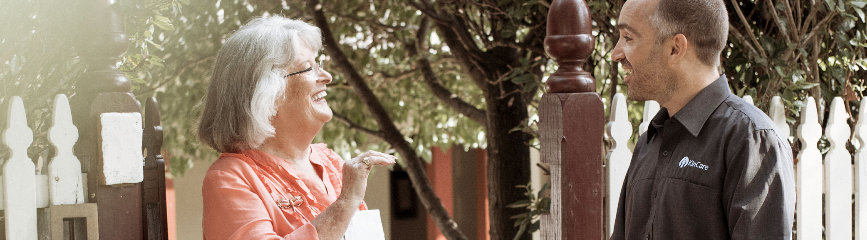 elderly woman smiling and talking to kincare worker