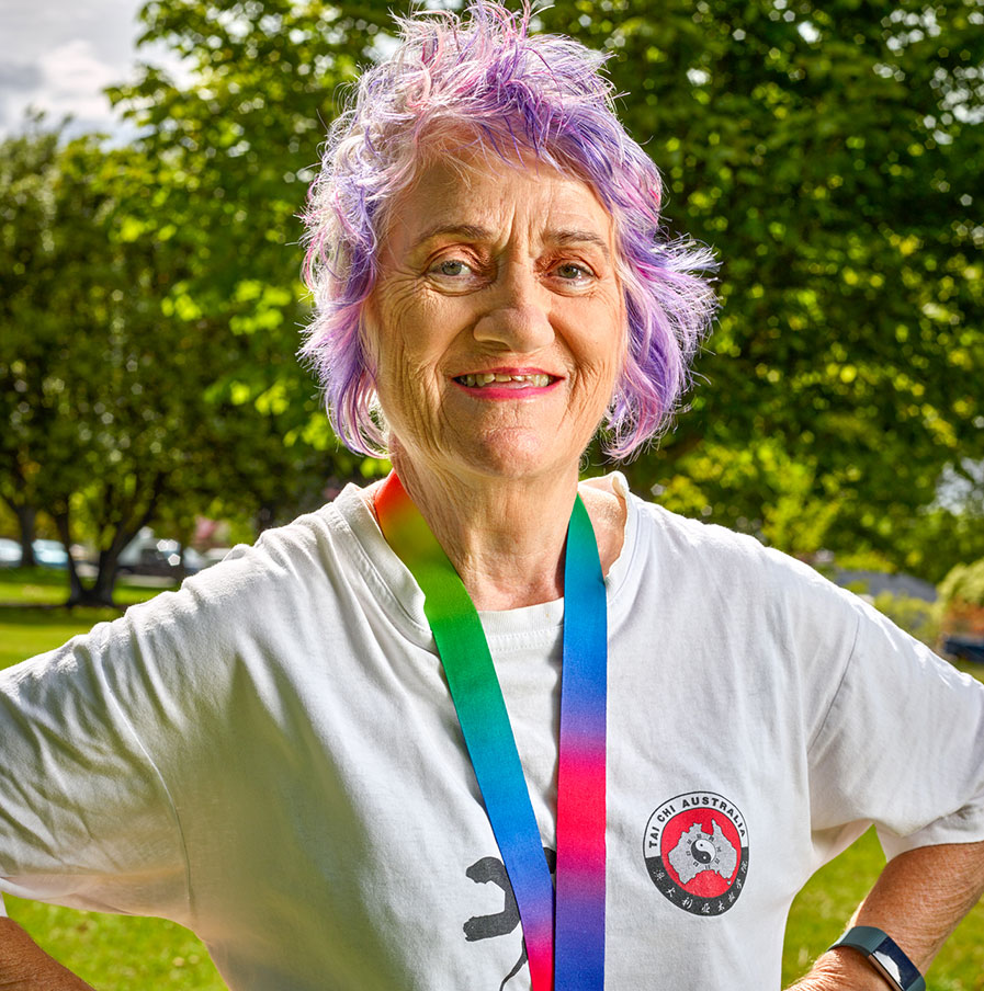 KinCare Customer Roberta smiling with her purple pink hair and taichi t-shirt