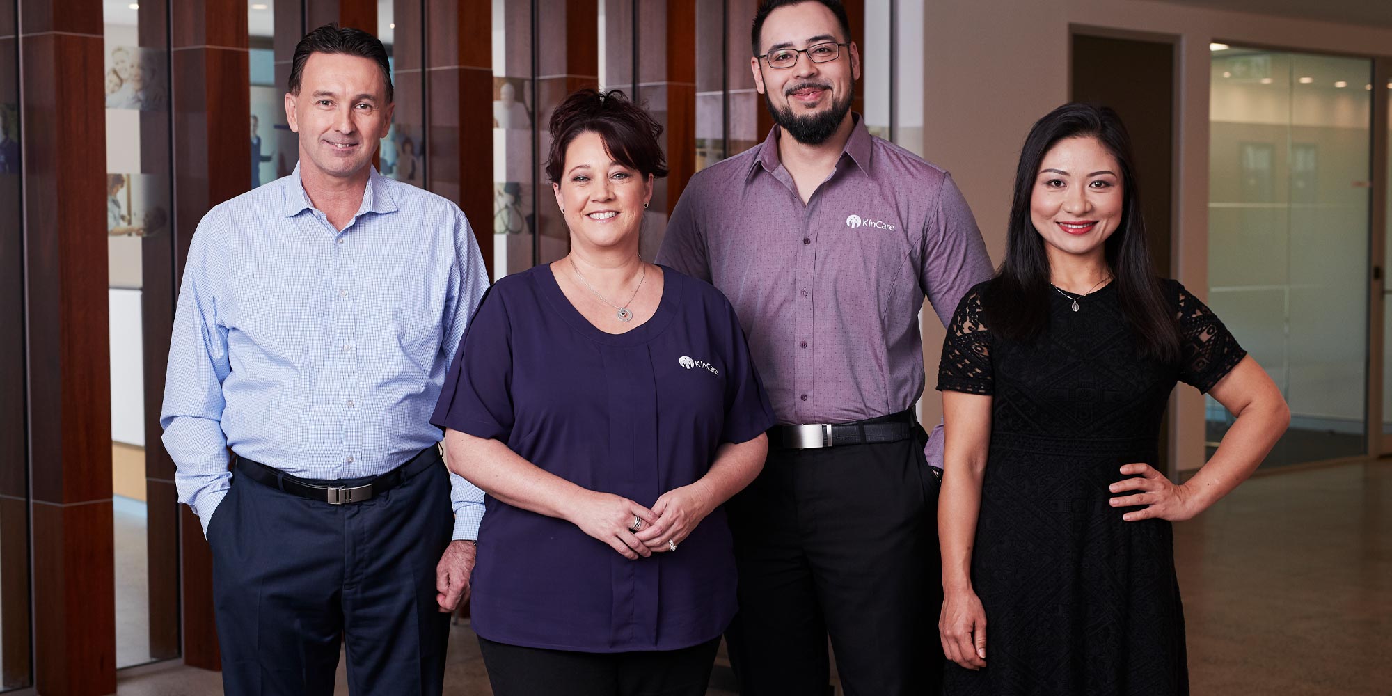 4 kincare workers standing and smiling straight to camera